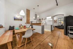 A modern kitchen with a central island, wooden flooring, and pendant lighting. - 1 BR Apartment in Neubau, 8 min city center, AC (Wien)