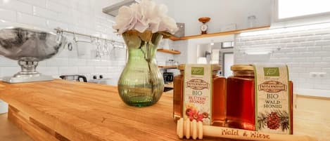 A kitchen counter with a vase, honey jars, and a honey dipper.