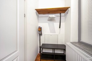 A narrow room with a white door, a radiator, a black shelf, and a ceiling-mounted vent. - 1 BR Apartment in Neubau, 8 min city center, AC (Wien)
