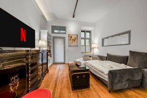 A modern living room with a sofa, a coffee table, and a TV mounted on the wall. - 1 BR Apartment in Neubau, 8 min city center, AC (Wien)
