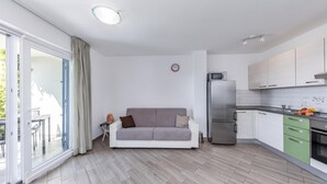 Un apartamento moderno con kitchenette, un sofá y comedor.