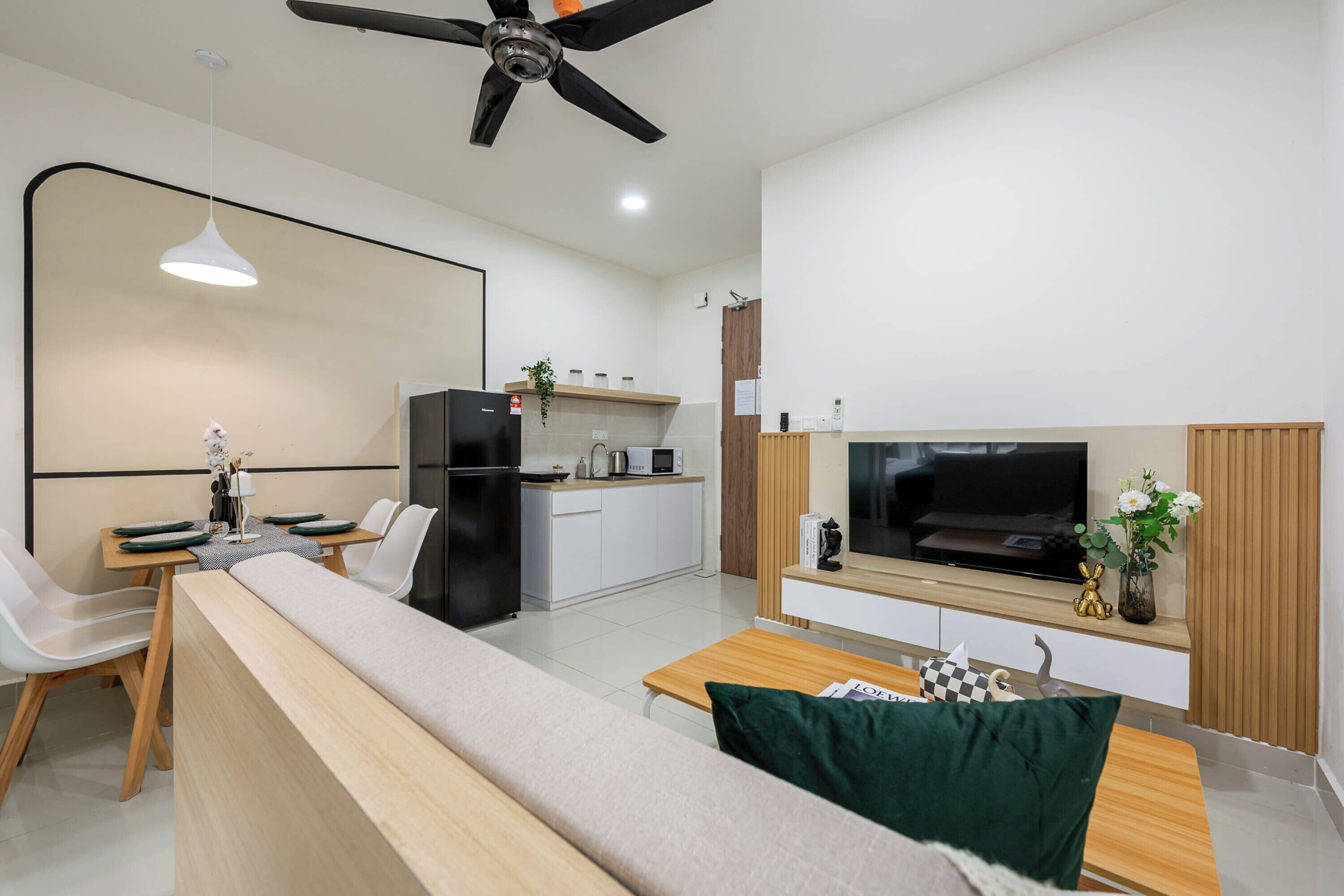 Una sala de estar moderna con sofá, mesa de comedor y zona de cocina.