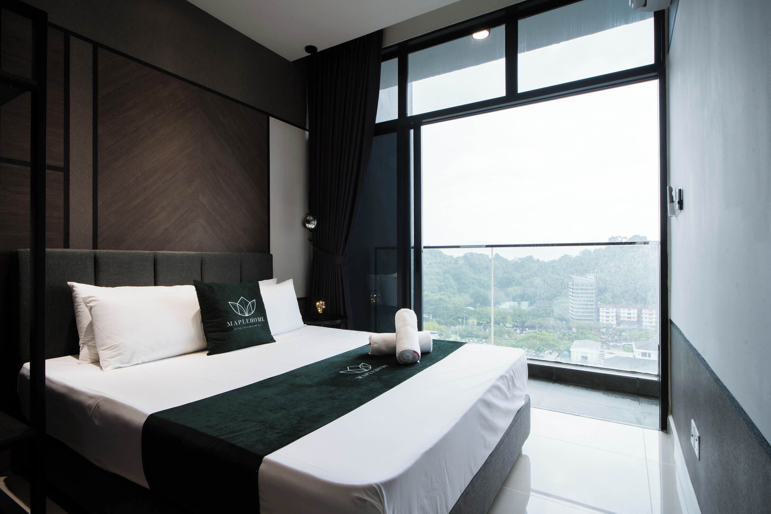 A modern hotel room with a large bed, a view of the city, and a balcony.