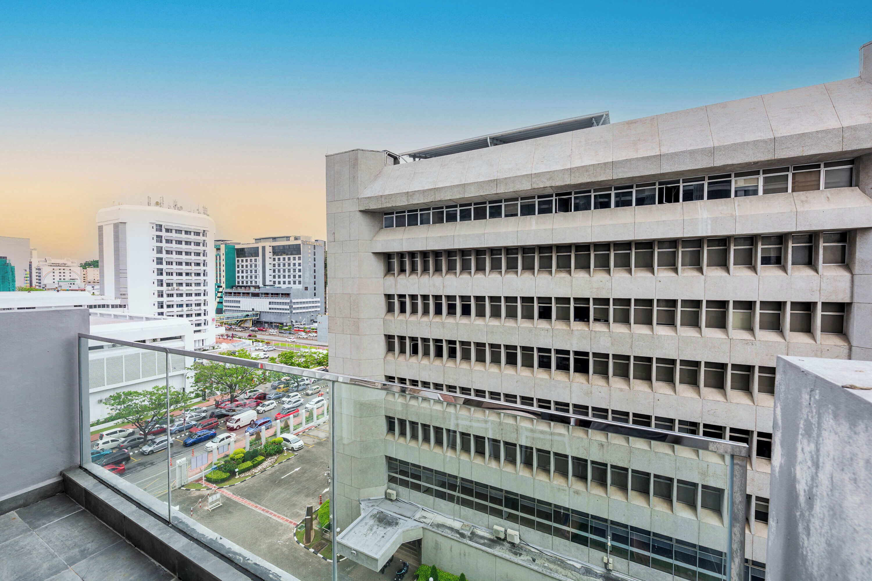 A modern building with multiple floors and a parking lot visible below.