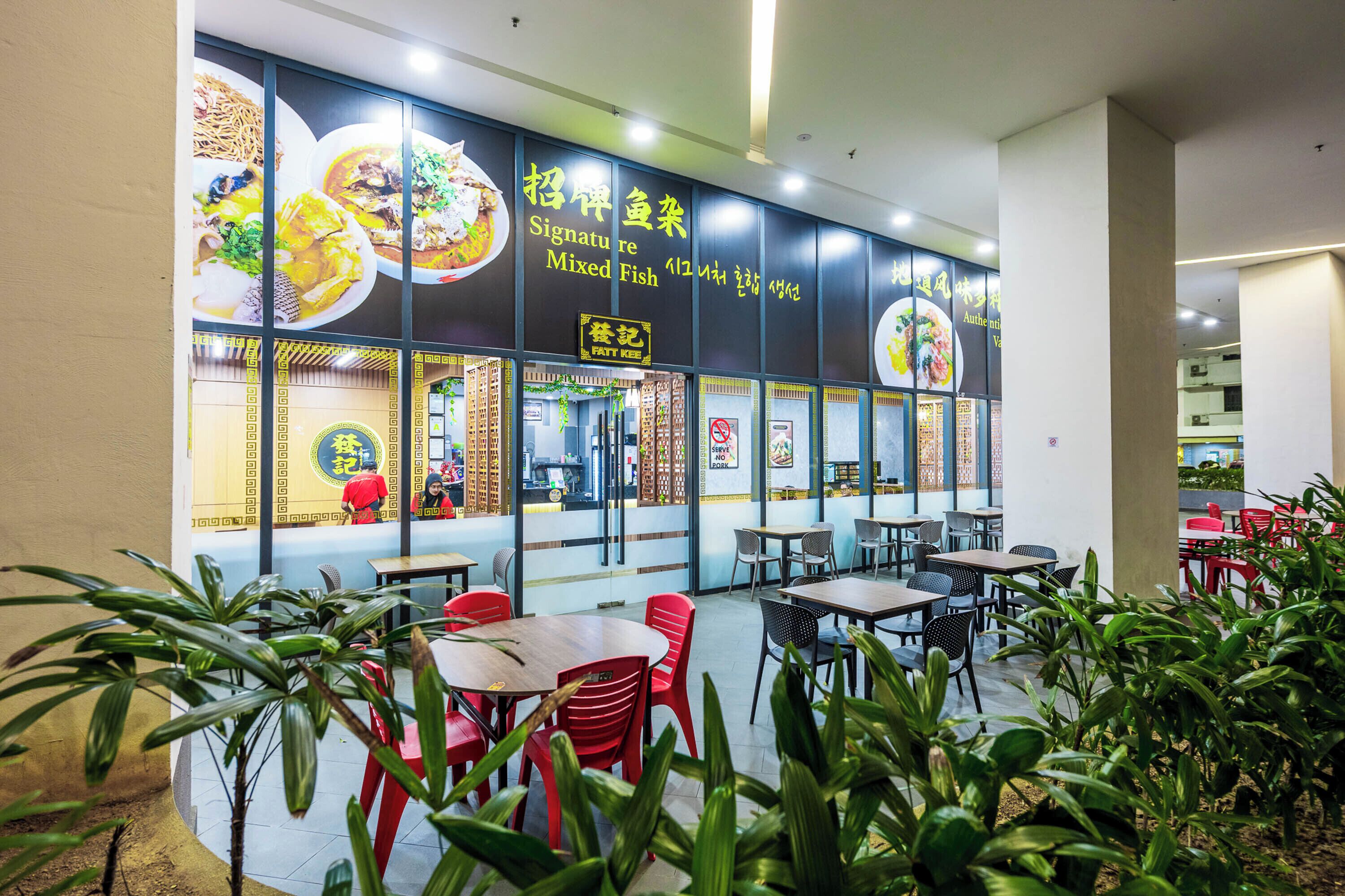 A restaurant with a sign for 'Signature Mixed Fish' and a 'Fatt Kee' sign.