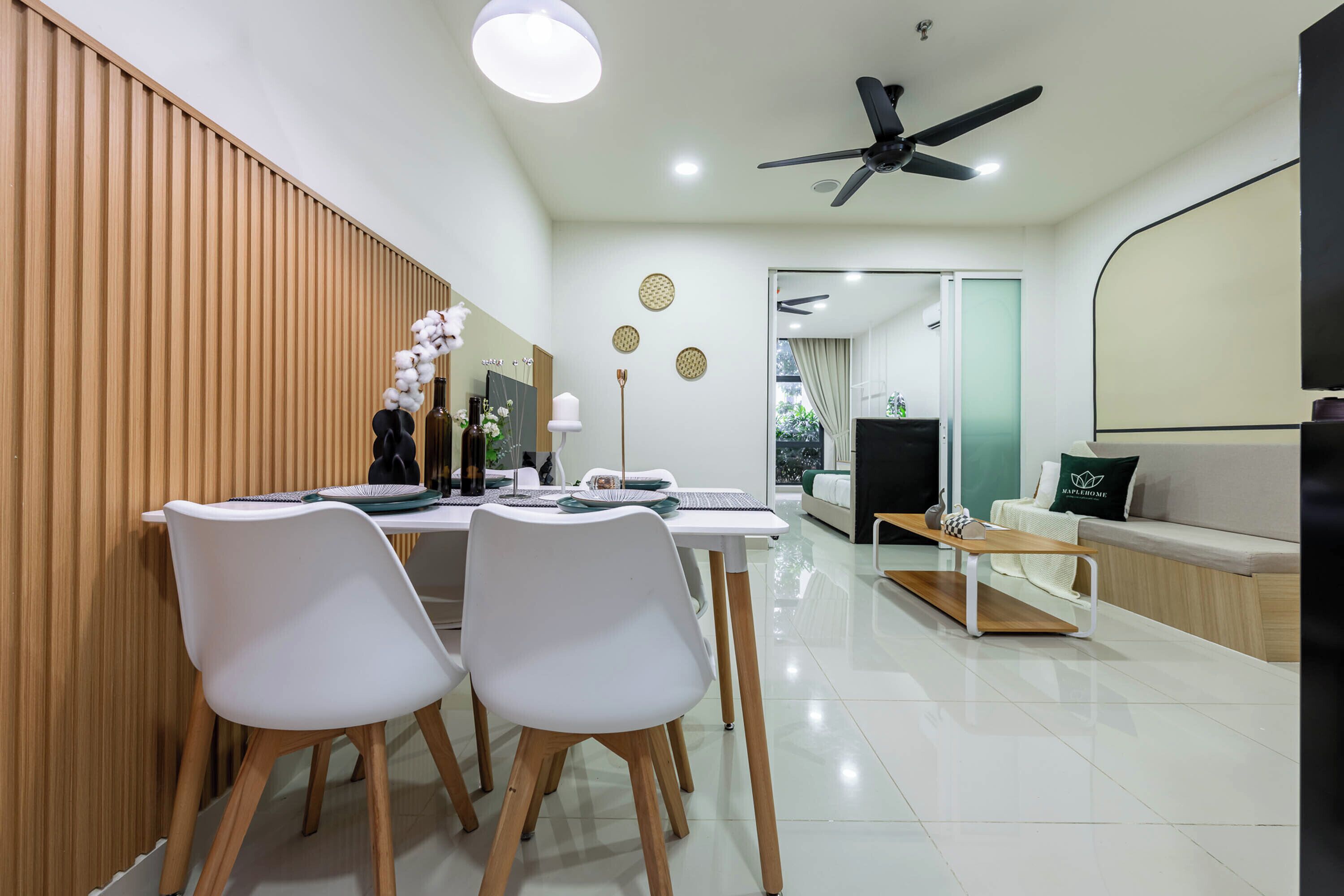A modern dining area with white chairs, a wooden table, and a ceiling fan.