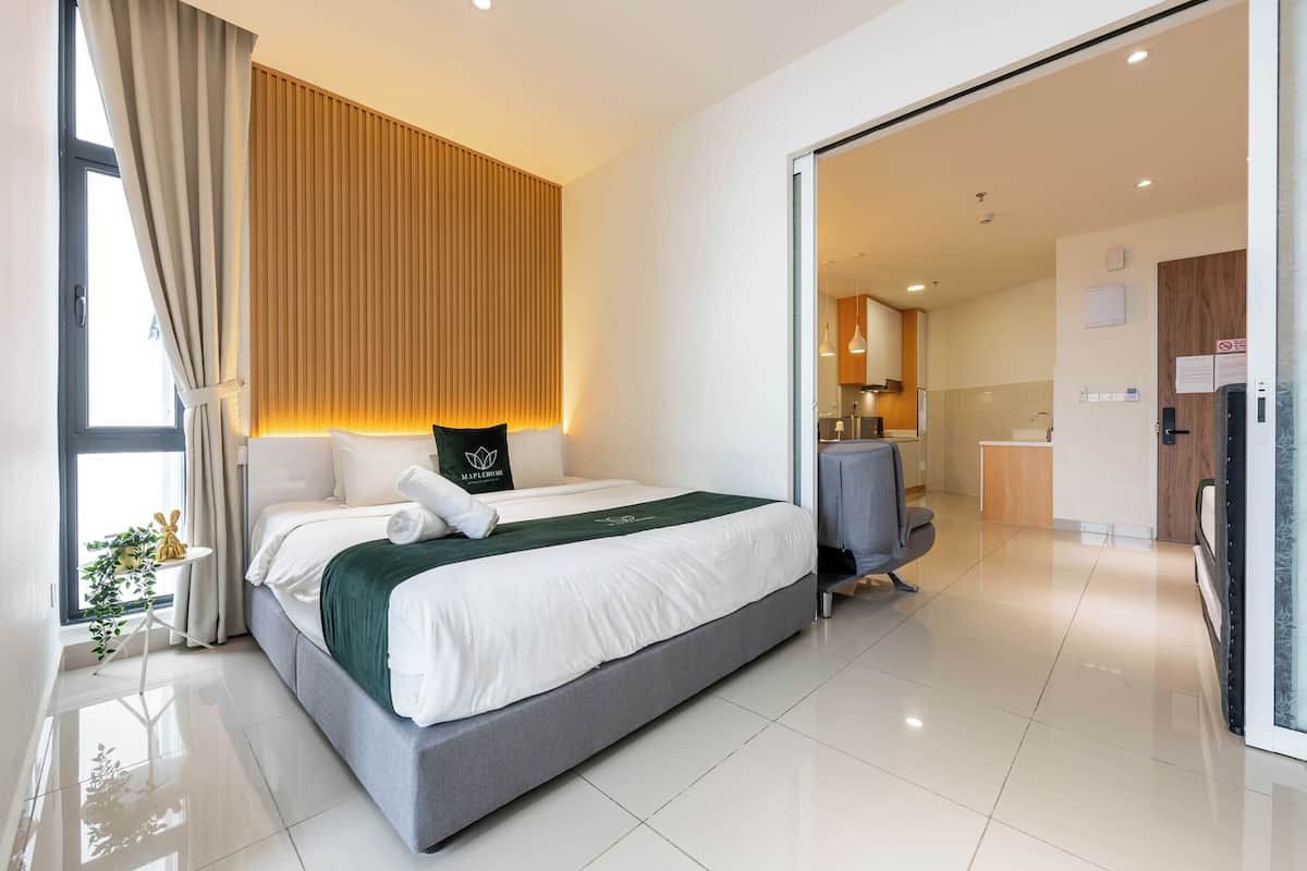 Una habitación de hotel moderna con una cama grande, un escritorio y vistas a la cocina.