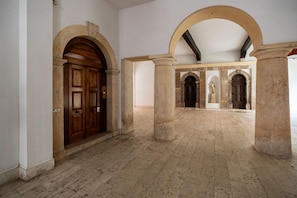 An interior with arched doorways, a tiled floor, and a statue. - Luxurious Maffei Palace - Domus Verona (Verona)