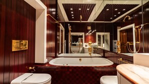 Ein modernes Badezimmer mit einer großzügigen Badewanne, zwei Toiletten und einem Waschtisch mit Spiegel.