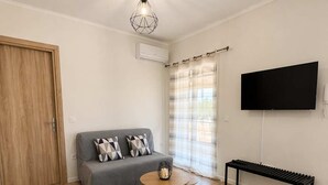 Een moderne woonkamer met een bank, een salontafel, een lange bank en een televisie.