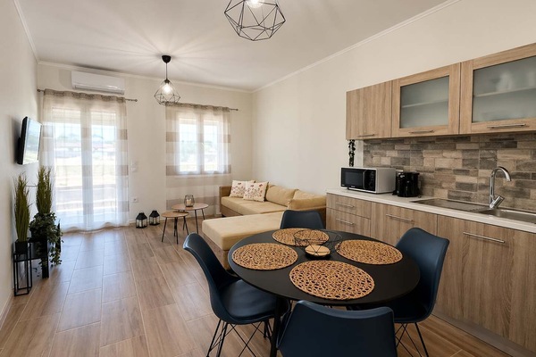 The open-plan living and kitchen area feels bright and practical, with a dining table and seating arranged for easy meals and relaxed time indoors.