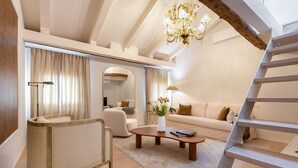 A modern living room with a sofa, armchair, coffee table, and a staircase. - Peaceful Cannaregio Top-Floor Apartment Steps from Ca’ D’Oro (Venice)