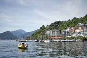 Un port avec des bateaux, un bateau jaune au premier plan et des bâtiments sur une colline.