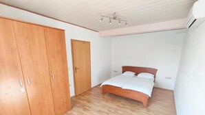 Ein Schlafzimmer mit einem Holzkasten, einem Bett mit weißer Bettwäsche und einem Holzboden.