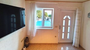 Ein Zimmer mit großem Fenster, einer Glastür, einer Tafel und einem Fliesenboden.