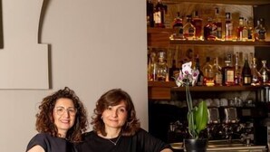 Two people standing near a reception desk with a wooden panel design and a bar area in the background. - Mediterraneo B&B (Pizzo)