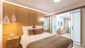 Un dormitorio moderno con una cama grande, cabecera de madera, mesitas de noche y vistas a un balcón.
