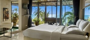 Ein Schlafzimmer mit einem großen Bett, einem Fernseher, einem Waschbecken und Blick auf den Ozean.