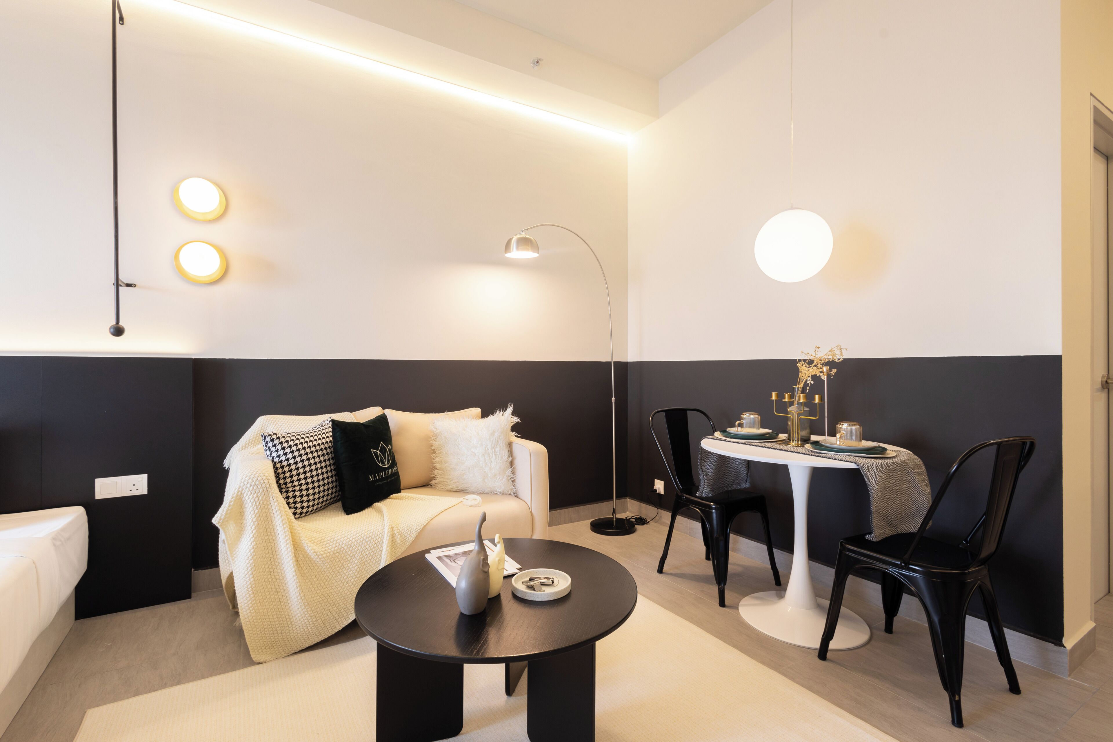 Una habitación moderna con sofá, una mesa redonda y dos sillas.