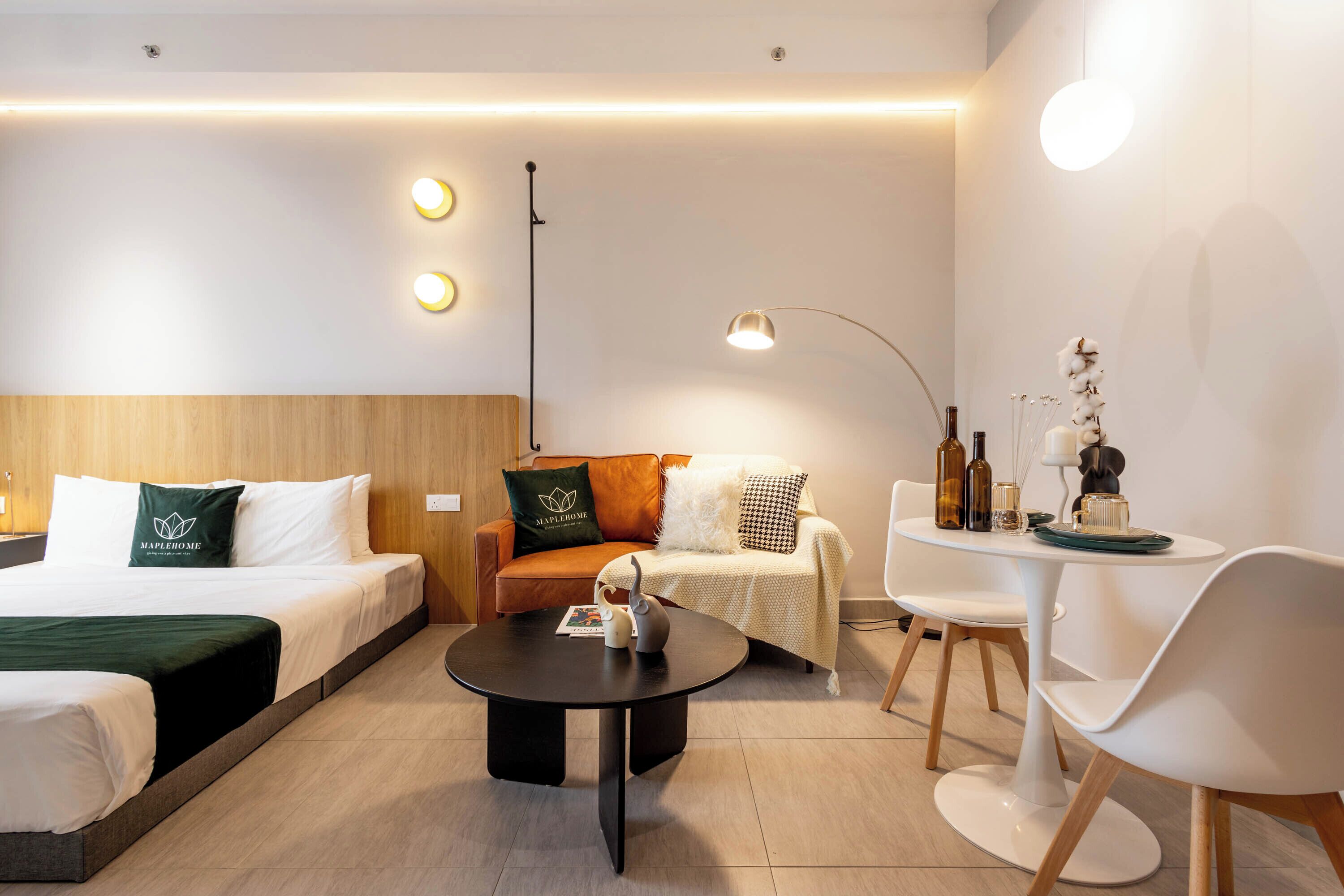 Une chambre d’hôtel comprenant un lit, un canapé, une table basse et une table à manger avec des chaises.