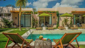 A poolside area with lounge chairs, a small table with a drink, and a clear view of the pool.