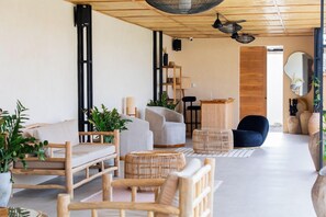 A modern living room with a sofa, chairs, a coffee table, and a dining area. - Nema Uluwatu (Pecatu)