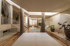 A spacious indoor area with a pool, columns, and potted plants. - Deluxe Imperial Punta Cana (Punta Cana)