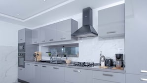 A modern kitchen with grey cabinets, a built-in oven, a gas stove, and a window above the sink. - sandra 11 (La Marsa)