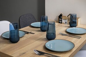 A dining table with blue plates, clear glassware, and cutlery. - City Vibes - 2-BR Apt. with Backyard in kolonaki (Athens)