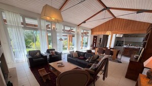 Un espacio habitable amplio con una mesa de comedor, sofás y una cocina al fondo.