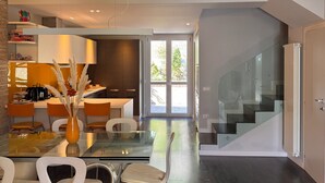 Una cocina moderna con comedor, una escalera y vistas al exterior.