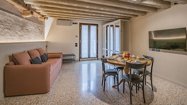 Un coin repas avec une table ronde, des chaises et une table préparée pour le petit-déjeuner.