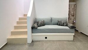 Een trap die leidt naar een ingebouwde zithoek met een met kussens beklede bank.