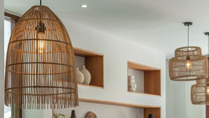 Ein Essbereich mit Holztisch, Schüsseln und einem Fernseher im Hintergrund.