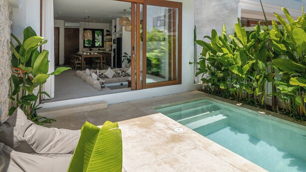 Ein modernes, zweistöckiges Haus mit Pool, Außenbereich und üppigem Grün.