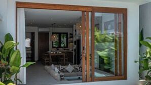 Ein modernes Haus mit Pool, Essbereich und Wohnzimmer mit Sofa.