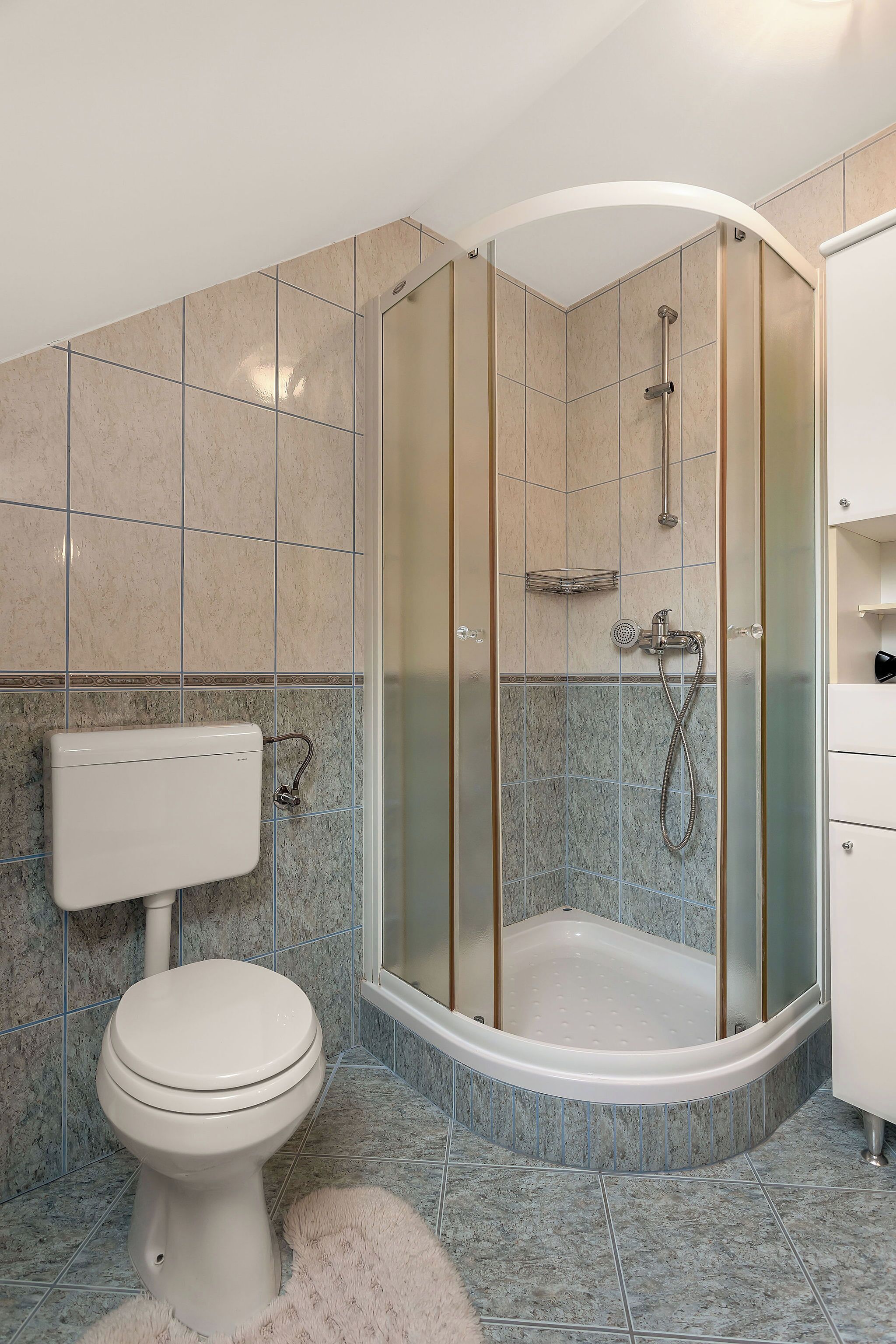 A bathroom with a toilet, shower, and sink.