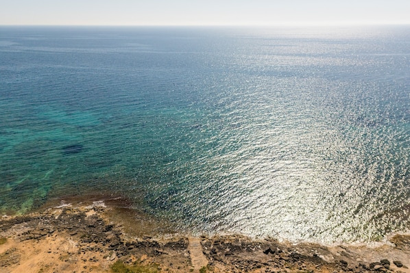 Eine Küstenlandschaft mit freiem Blick auf das Meer und eine felsige Küste.