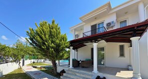 Un bâtiment à deux étages doté d’un porche abrité, d’une piscine et d’un jardin.