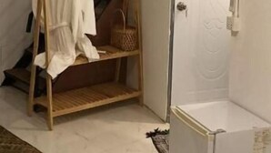 A room with a white door, a wooden chair with a white cloth, a small wooden table, and a staircase. - Reaksa Hostel Koh Rong (Koh Rong)