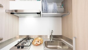 Een moderne keuken met een gasfornuis, een roestvrijstalen spoelbak en een afwassysteem.