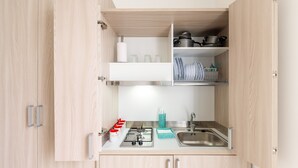 Een keuken met een gasfornuis, een spoelbak en kasten.