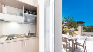 Een moderne keuken met een gasfornuis, spoelbak en open planken.