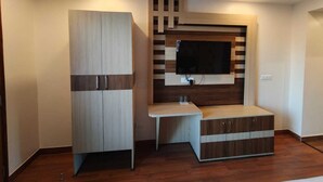 A room with a built-in TV, a wooden cabinet, and a small table. - Summer hill resort (Shimla)