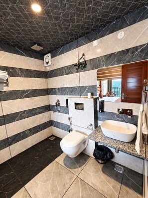 Een moderne badkamer met een groot bad, een apart toilet en een wastafelmeubel met een wastafel.