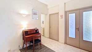 A hallway with a piano, a door with frosted glass panels, and a wall-mounted light fixture. - New! N&J -LE CATINAT - Spacious - Balcony (Nice)