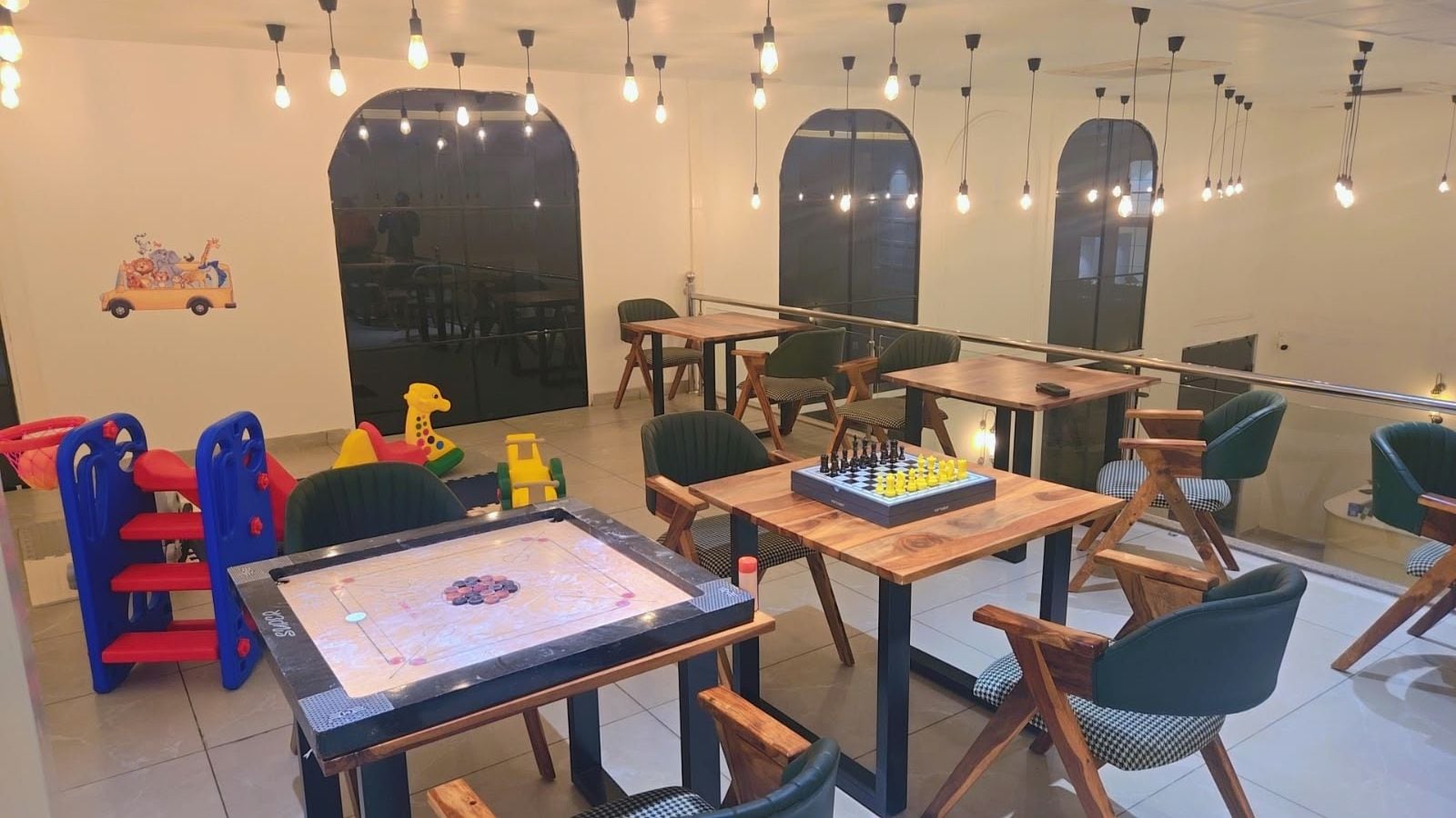 Ein Kinderspielbereich mit Tischen, Stühlen und Spielzeug.