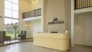 A reception desk with a logo, a balcony, and seating area with a view. - Aayovea Resort Ayodhya Near Ram Mandir & Saryu River (Ayodhya)