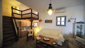 Un interior acogedor con una cama litera, un sofá, una mesa de centro y una zona de cocina.