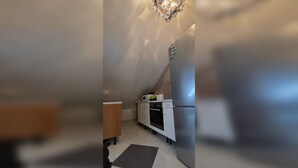 Une cuisine équipée d’un réfrigérateur, d’un four à micro-ondes, d’un four traditionnel et d’un meuble en bois.